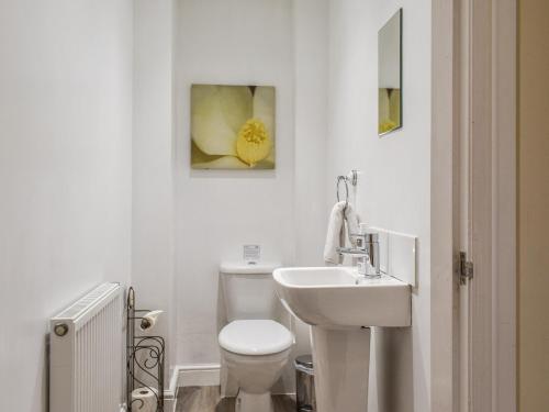 La salle de bains blanche est pourvue de toilettes et d'un lavabo. dans l'établissement Marina View, à Burton