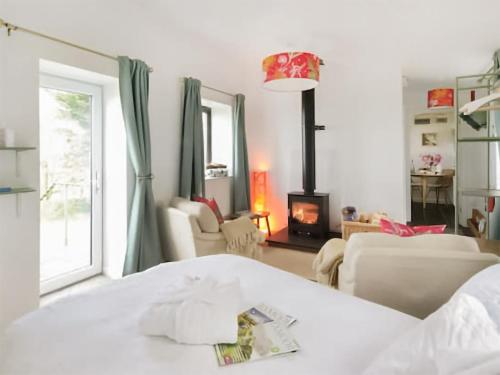 a living room with a bed and a fireplace at The Hideaway in Kilve