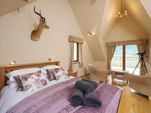 a bedroom with a bed with a deer head on the wall at Skye Fall in Letterfinlay