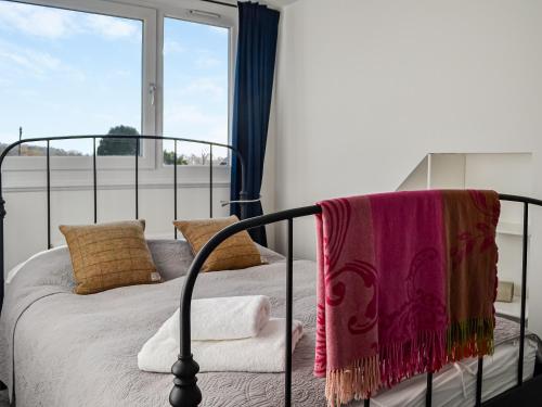 a bedroom with a bed and a large window at The Cottage in Leitholm