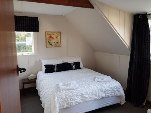 a bedroom with a bed with two towels on it at Riverhead Villa in Horoeke