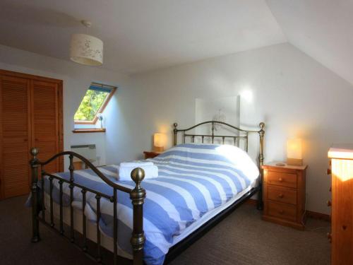 a bedroom with a bed with a blue and white striped blanket at The Old Chandlery in Avoch