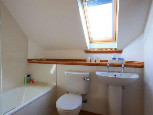 uma casa de banho com um WC, um lavatório e uma janela em The Old Chandlery em Avoch