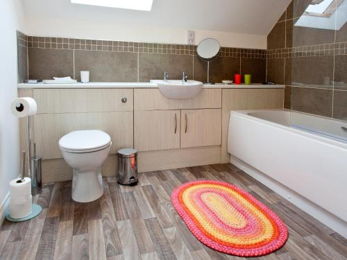 a bathroom with a toilet and a sink and a rug at Number 2 - Uk7451 in Dornoch