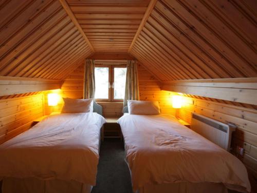 Balintore的住宿－Taigh Fiodha，木屋内设有一间带两张床的卧室