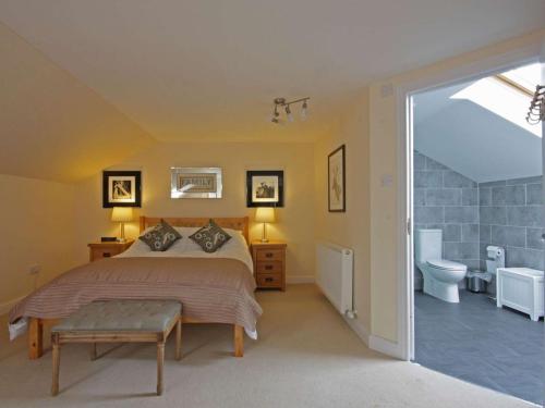 a bedroom with a bed and a bathroom with a toilet at Fairway Apartment in Nairn