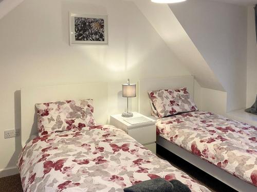 a bedroom with two beds and a lamp at Uk7471 - Otterburn 1 in Aultgrishin