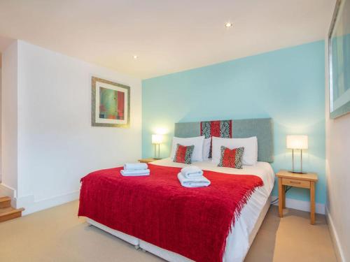 a bedroom with a large bed with a red blanket at 208 By The Bridge Apartment in Inverness