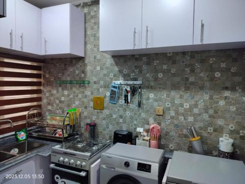 een keuken met witte kasten en een fornuis met oven bij UCLAS Gorgeous Apartment in Port Harcourt