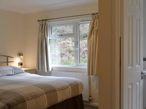 1 dormitorio con cama y ventana en Island View Lodge, en Tarbert