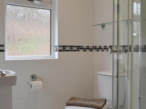 La salle de bains est pourvue de toilettes et d'une fenêtre. dans l'établissement Island View Lodge, à Tarbert