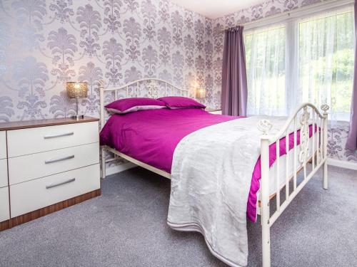 a bedroom with a white bed and a pink bedspread at Tighur in Kintail