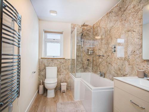 a bathroom with a toilet and a tub and a sink at Terra Verde in Beauly