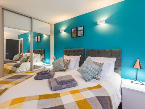 a bedroom with a large bed with blue walls at Garden Views - Ukc5414 in Broadstairs