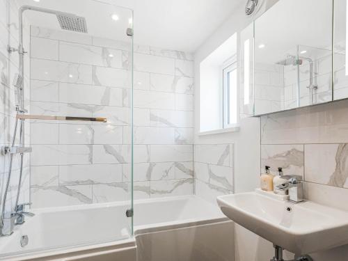 uma casa de banho branca com um chuveiro e um lavatório. em Garden Views - Ukc5414 em Broadstairs