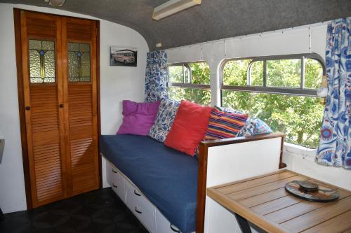 Habitación pequeña con cama y mesa en Evi the school bus at Oromahoe Downs Farm, en Puketona