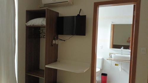a bathroom with a sink and a toilet and a mirror at Pousada Souza & Souza in Barra Velha