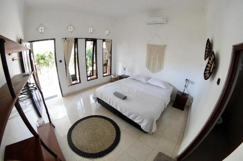 ein Schlafzimmer mit einem Bett in einem Zimmer mit Fenstern in der Unterkunft Jepun Villa 04 - One Bedroom without kitchen in Uluwatu