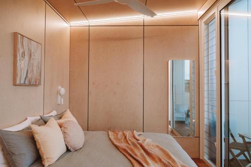 1 dormitorio con cama y espejo en Pod-e Luxury Accommodation - Mulla Mulla, en Streaky Bay