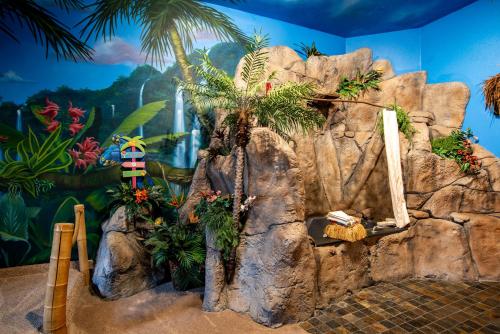 a room with a rock wall with a palm tree at The Anniversary Inn - Boise in Boise