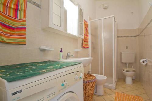 a bathroom with a sink and a washing machine at Case vacanze Mirko IMPERIA BORGO MARINA in Imperia