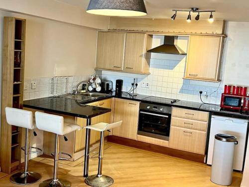 a kitchen with a black counter and white appliances at Chancellor Apt Nr Uni/Hosp/CityCtr & all Amenities in Liverpool