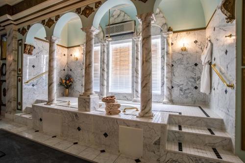 a large bathroom with a large tub with columns at The Anniversary Inn - Boise in Boise