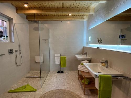 ein Bad mit einer Glasdusche und einem Waschbecken in der Unterkunft Deich21-Haus Langeoog in Wangerland