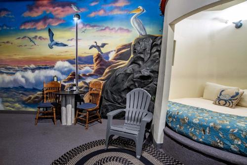 a room with a bedroom with a mural of birds at The Anniversary Inn - Boise in Boise