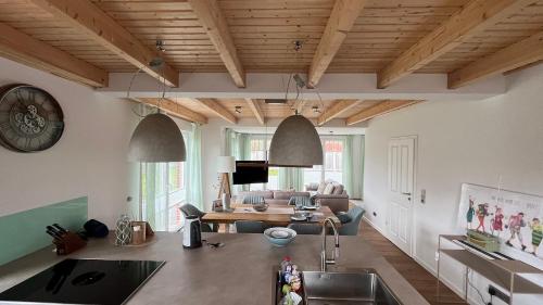 eine Küche und ein Wohnzimmer mit Holzdecken in der Unterkunft Deich21-Haus Langeoog in Wangerland