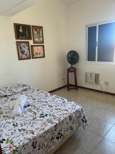 um quarto com uma cama com um edredão floral em O Paraíso é aqui: Pé na Areia em Arembepe em Camaçari