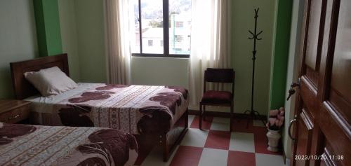 Cette petite chambre comprend 2 lits et une fenêtre. dans l'établissement HOSTAL ETERNA PRIMAVERA, à Copacabana