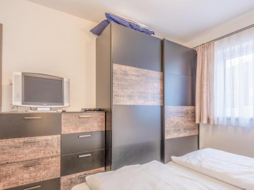 1 dormitorio con 1 cama y TV en Blick auf den Rettenstein Top 1, en Kirchberg in Tirol