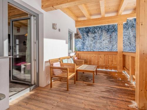 a living room with a table and chairs on a wooden floor at Blick auf den Rettenstein Top 2 in Kirchberg in Tirol