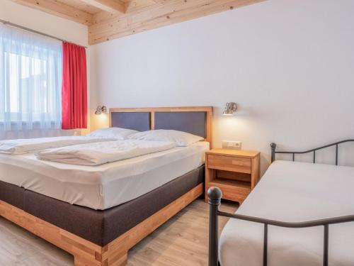1 dormitorio con 2 camas y ventana en Blick auf den Rettenstein Top 2, en Kirchberg in Tirol