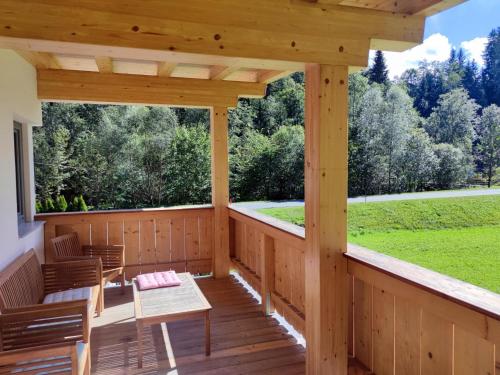 a wooden porch with a table and chairs on it at Blick auf den Rettenstein Top 2 in Kirchberg in Tirol