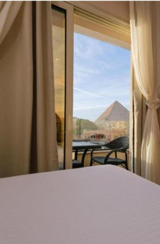 a bedroom with a window with a view of a patio at Royal pyramids residential in Ghaţāţī