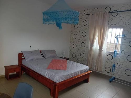 een slaapkamer met een bed en een raam bij Partners Residence in Douala