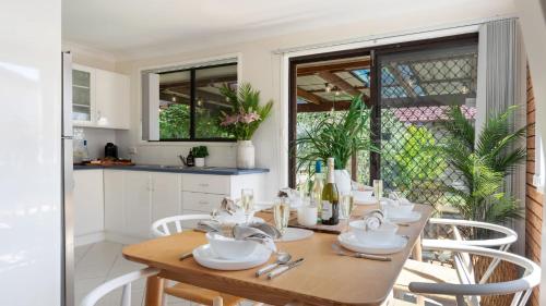 a kitchen and dining room with a wooden table and chairs at Sunrise Sands in Callala Beach