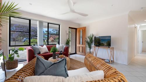 a living room with a couch and a tv at Sunrise Sands in Callala Beach