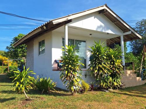 a small white house with plants in front of it at Miss You Beach Resort Koh Mak in Ko Mak