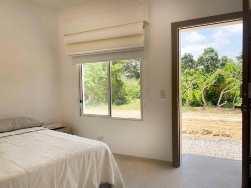 ein Schlafzimmer mit einem Bett und einem großen Fenster in der Unterkunft Estudio 1, Las Castañas in Santa Elena