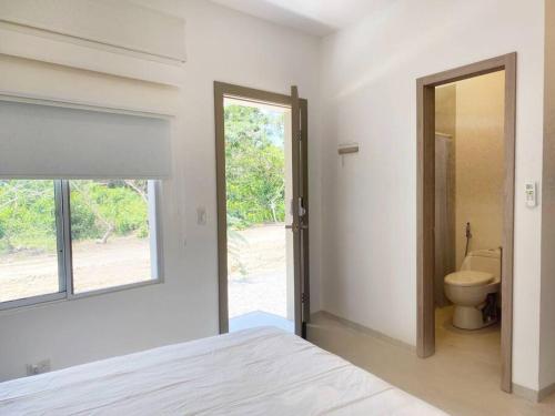 ein Schlafzimmer mit einem Bett, einem WC und einem Fenster in der Unterkunft Estudio 1, Las Castañas in Santa Elena