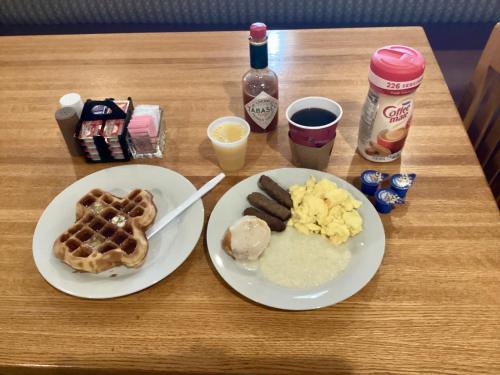 a table with two plates of waffles and eggs and syrup at GreenTree Hotel & Extended Stay I-10 FWY Houston, Channelview, Baytown in Channelview