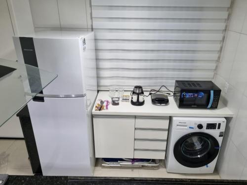 a small kitchen with a refrigerator and a washing machine at Apartamento super novo, ótima localização na praia do Recreio! in Rio de Janeiro
