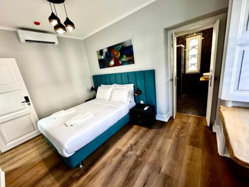 a bedroom with a large bed with a blue headboard at Relax and Explore Lisbon Suites and Rooms in Lisbon