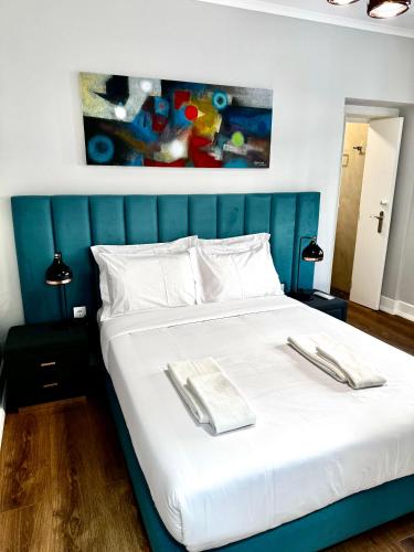 a bedroom with a large white bed with a blue headboard at Relax and Explore Lisbon Suites and Rooms in Lisbon
