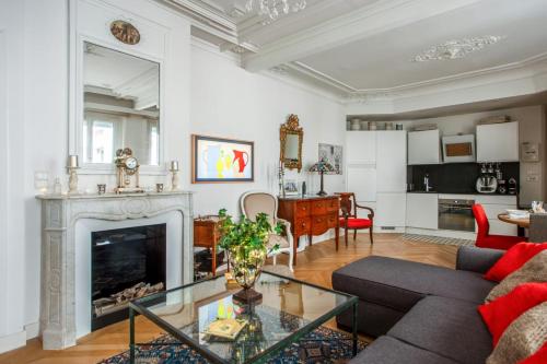 un salon avec une cheminée et un canapé dans l'établissement Appartement Folletto - Welkeys, à Paris