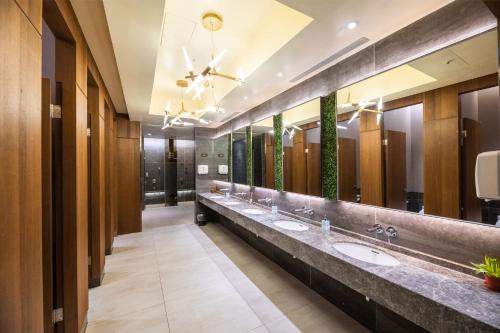 a bathroom with three sinks and a large mirror at Yamagata Kaku Hotel & Spa in Jiaoxi