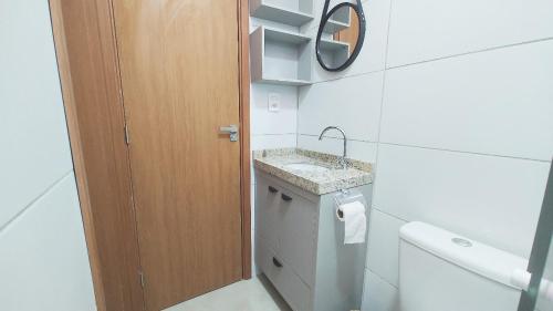 een badkamer met een wastafel, een toilet en een spiegel bij Vila Atlântida- Atalaiaape307-B in Luis Correia